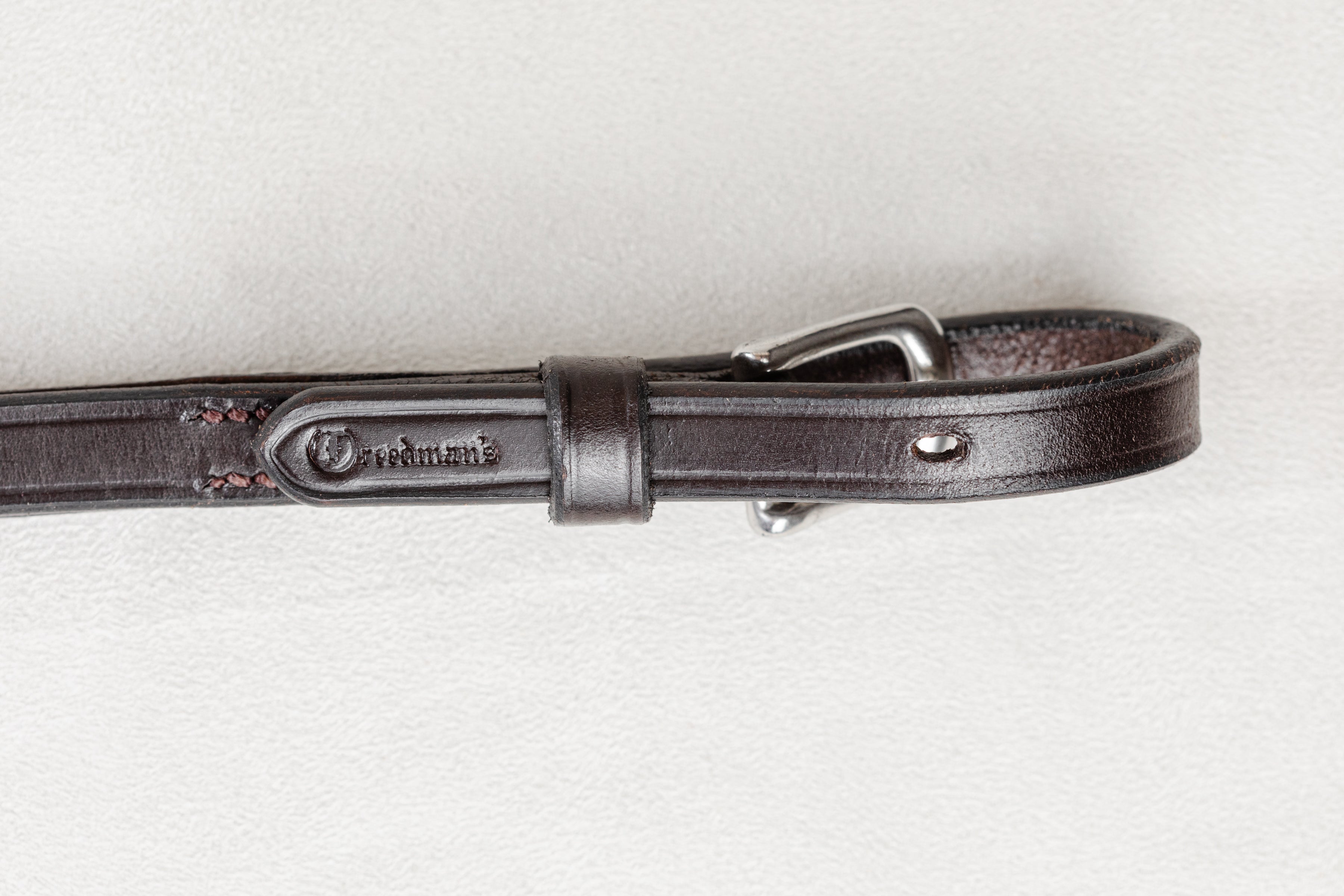 Brown leather belt with a silver buckle on a white background