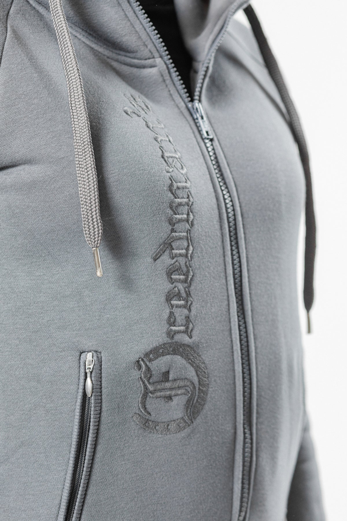 Ash Grey Ladies' Logo Hoodie by Freedman's, close-up showing embroidered "Freedman's" logo down the front and full zip closure.
