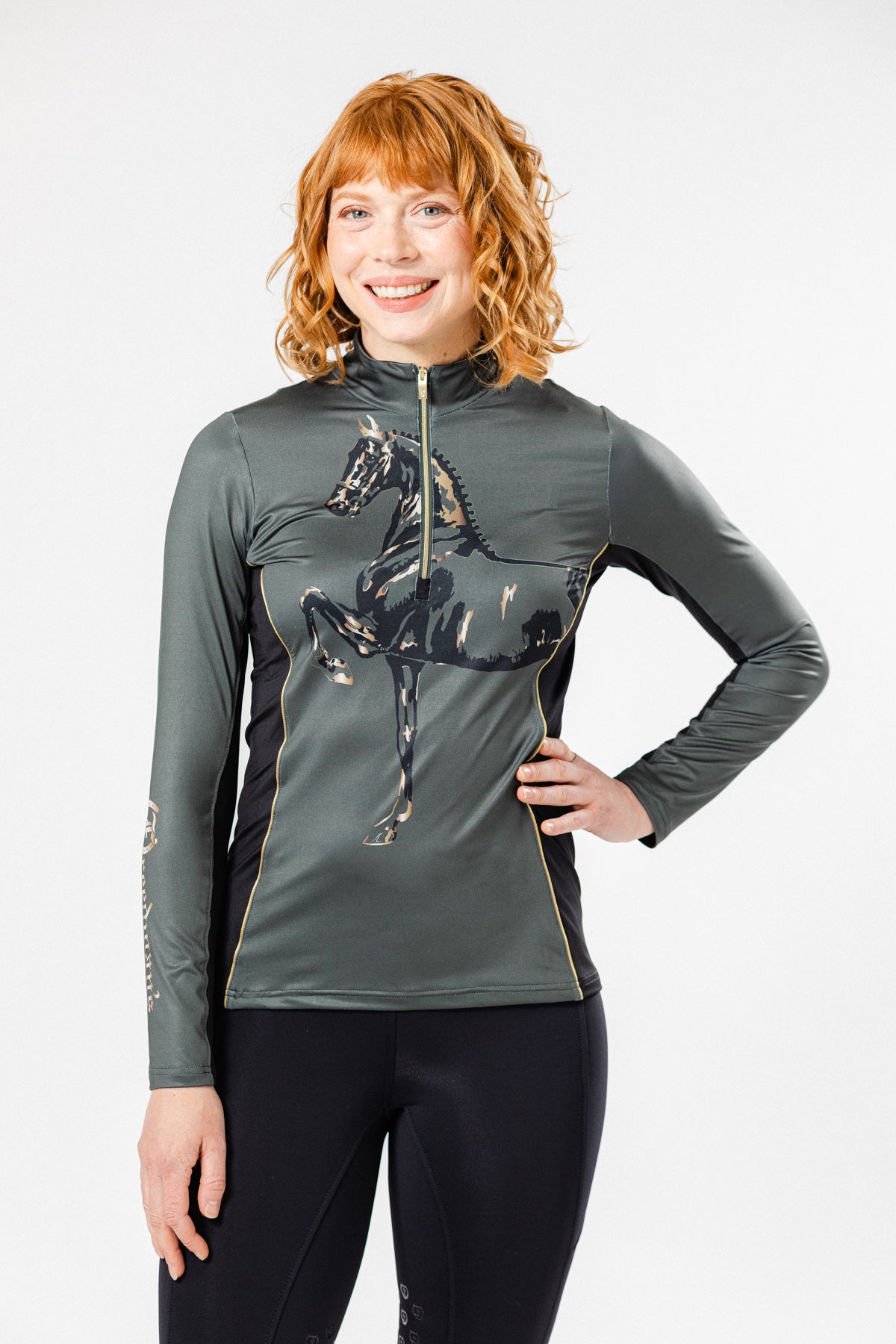 Model wearing the Midas 1/4 Zip Long Sleeve Shirt by Freedman's, featuring a stylish horse print design on a sleek, dark green athletic top with gold accents