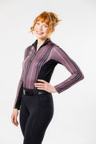 Here's an SEO-friendly alt text for the image you described:

Smiling woman in Freedman's Nancy 1/4 Zip Long Sleeve Shirt, angled with hand on hip, paired with black Jods and Freedman's belt.
