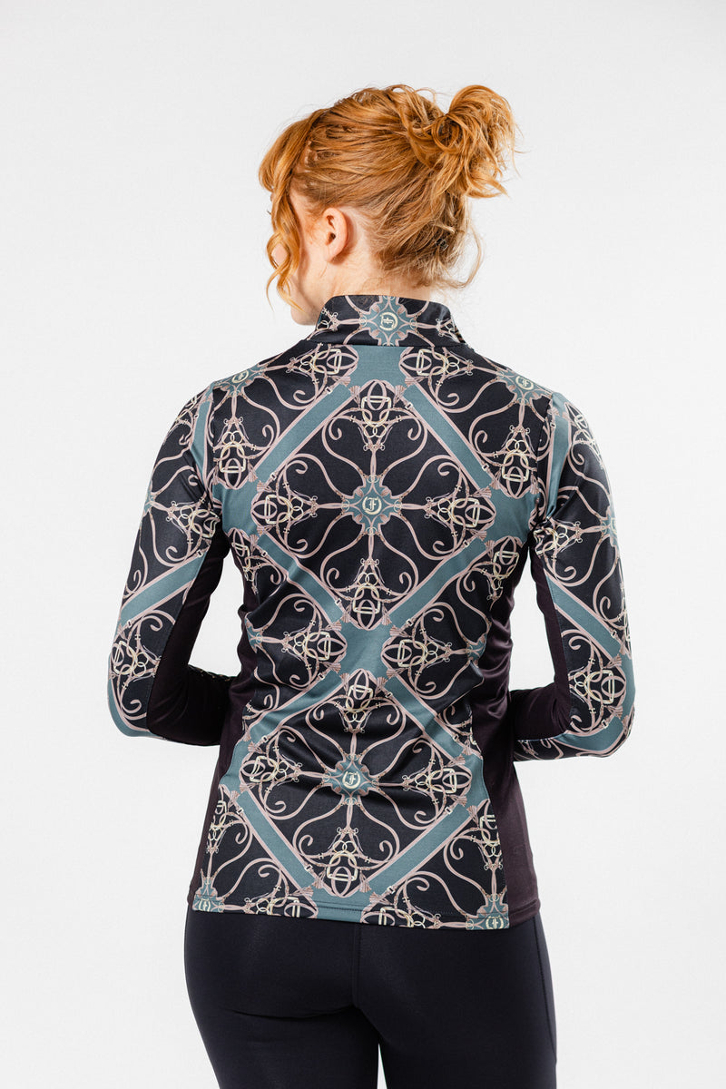 Women wearing the Fantasy 1/4 Zip Long Sleeve Shirt in Black/Forest print. Stylish equestrian-inspired performance top with an intricate geometric pattern, perfect for active and casual wear. Back View