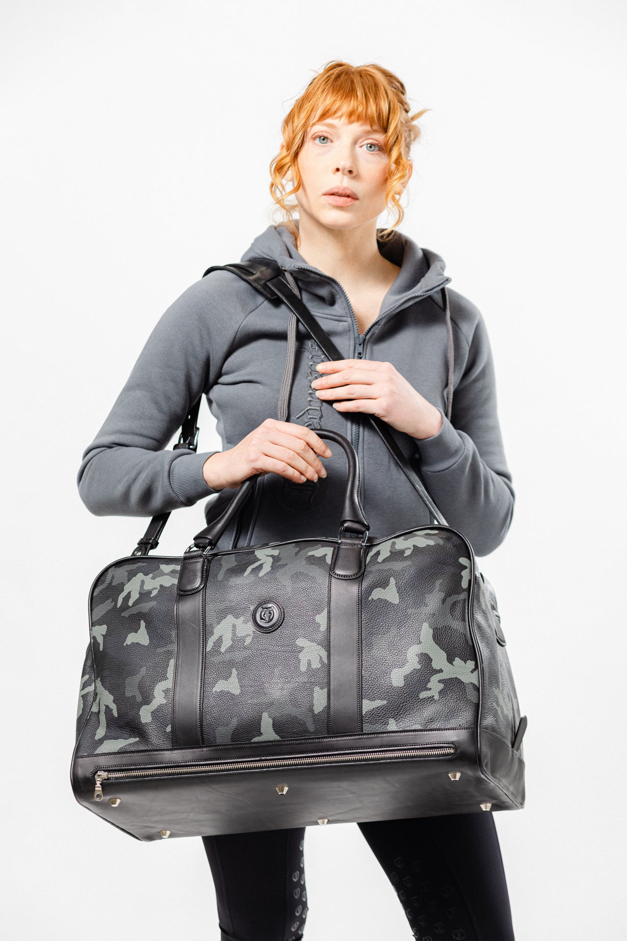 Women carrying The Grand Break travel bag by Freedman’s, a premium leather duffel with brass hardware, exuding style and sophistication.