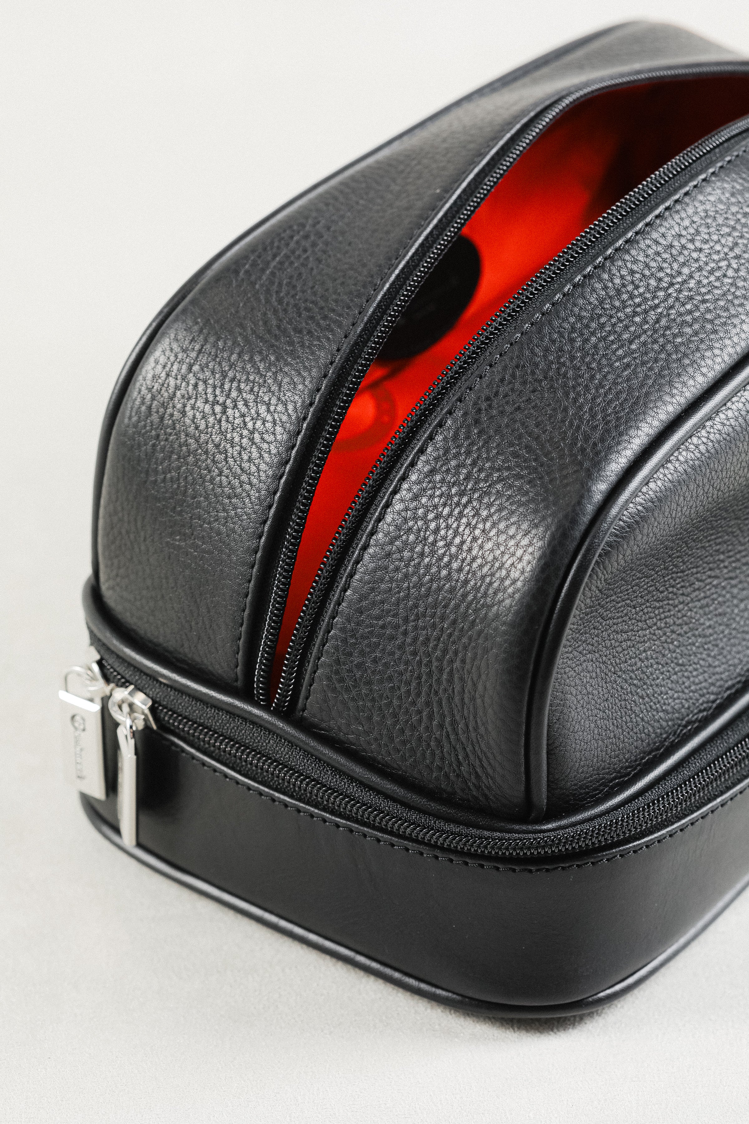 Freedman's Cardiff Shave Bag, Open View, Black Textured Leather Exterior, Dual Compartments with Bright Red Fabric Lining and Embossed "F" Logo Pattern, Silver Zipper Pulls