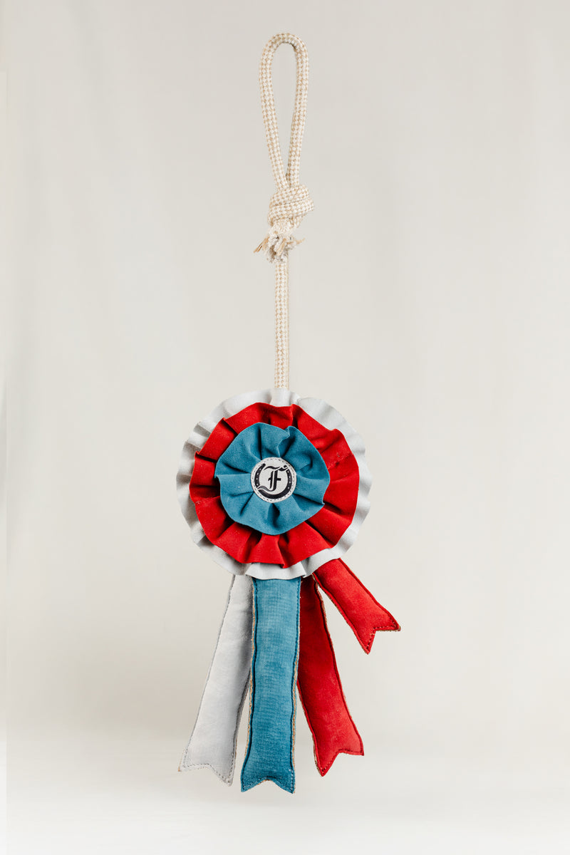 Decorative equestrian ribbon toy in red, blue, and white with the Freedman logo, hanging against a white background.