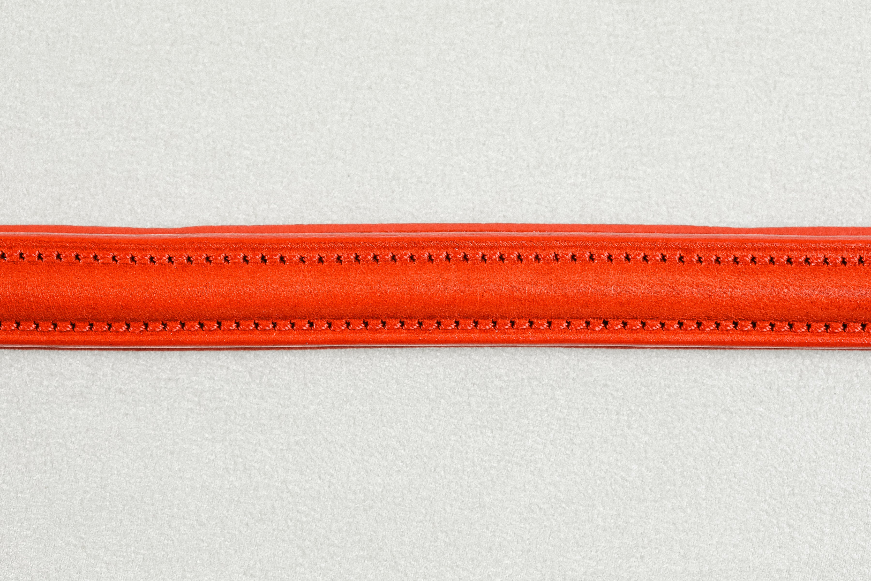 Close-up of Red leather of the Raised Dog Leash showing detailed stitching.
