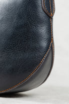 Detail Shot of Freedman's Murphy Bag, Emphasizing the Dark Navy Leather Grain and Orange Hand-Stitched Seam