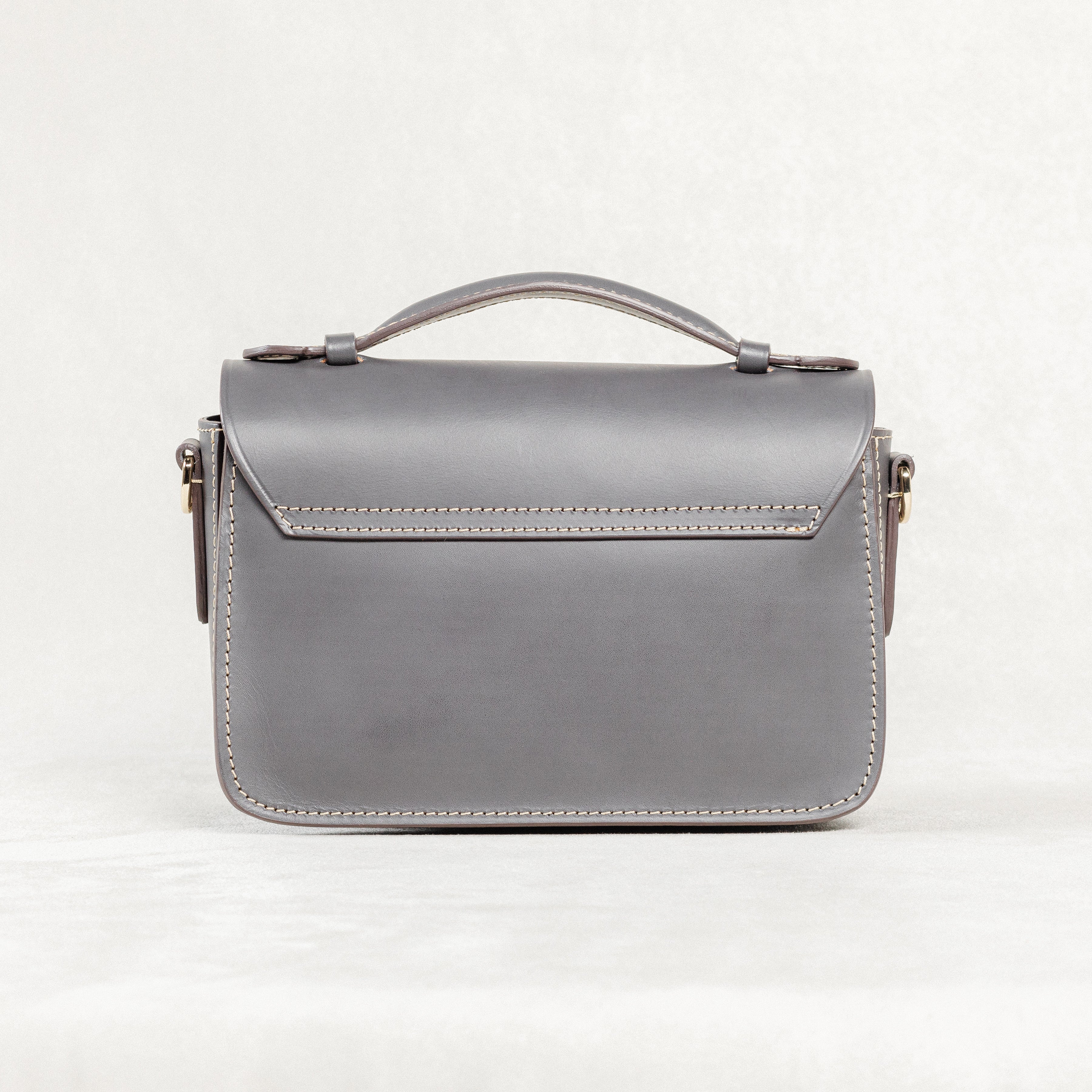 Back view of grey leather Mantelet Bag by Freedman's with top handle and stitching details.
