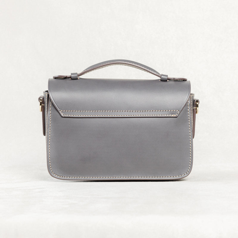 Back view of grey leather Mantelet Bag by Freedman's with top handle and stitching details.
