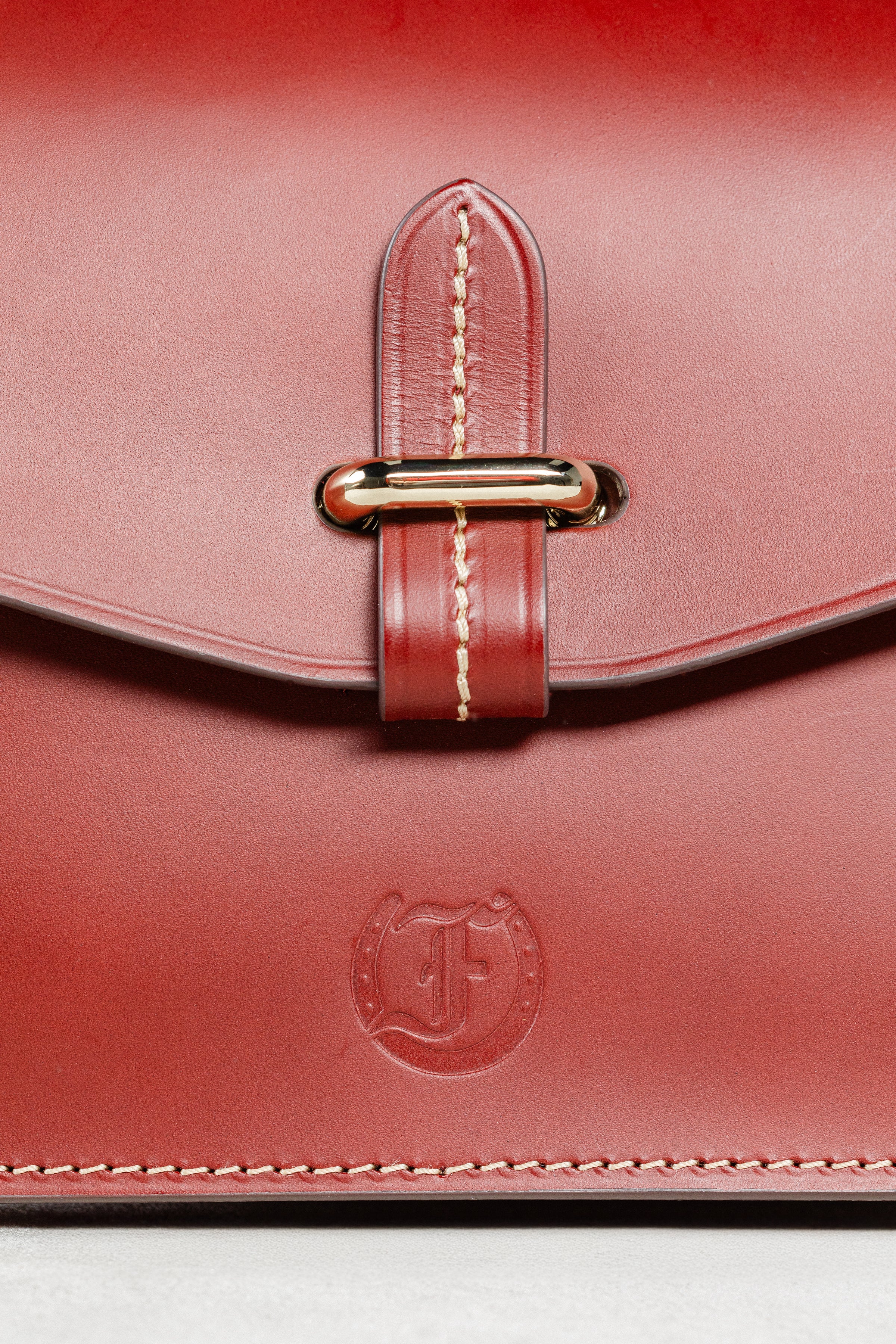 Close-up of Brunello leather Mantelet Bag by Freedman's, highlighting gold-tone slide lock, contrasting stitching, and embossed brand logo.