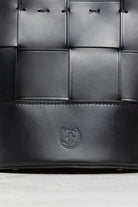 Close-up of Freedman's Milord Bag, black woven leather, showing logo.