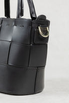 Close-up of black leather Milord Bag by Freedman's, highlighting gold-tone hardware and construction details.