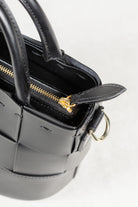Close-up of black leather Milord Bag by Freedman's, highlighting gold-tone zipper and ring hardware.