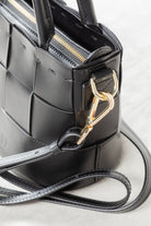 Close-up of black leather Milord Bag by Freedman's, highlighting gold-tone clasp hardware and adjustable strap attachment.