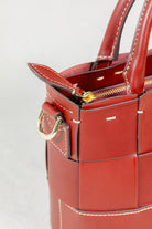 Close-up of Brunello leather Milord Bag by Freedman's, highlighting gold-tone zipper, ring hardware, and handle stitching.