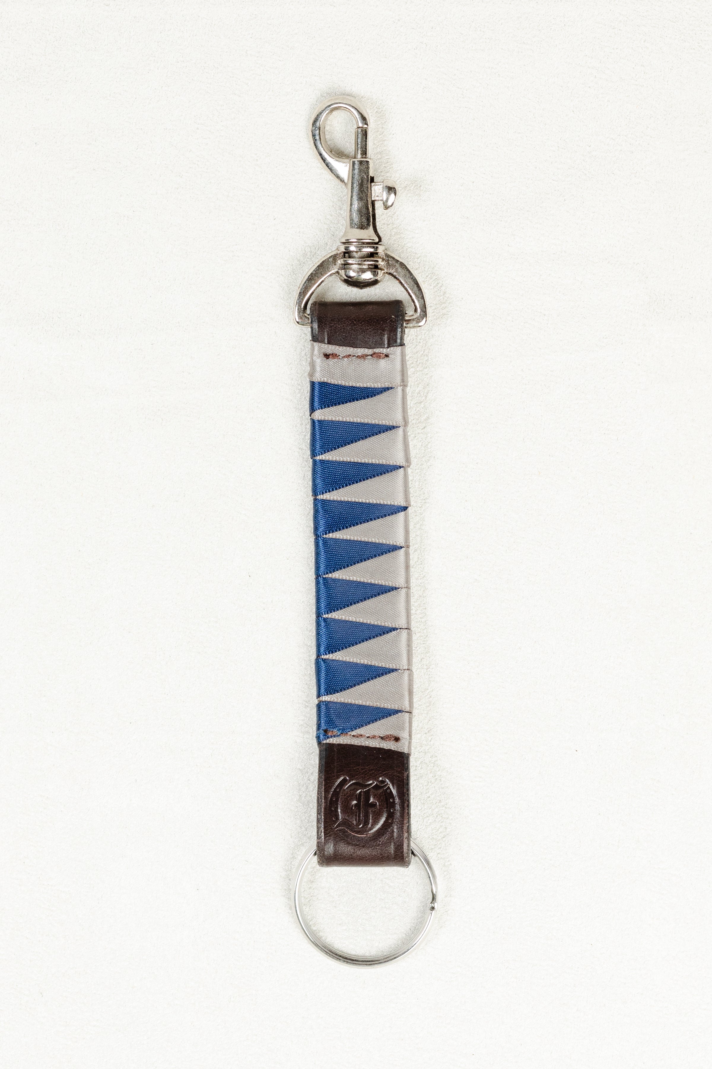 Blue and white satin-finished keychain in dark Havana brown bridle leather with stainless steel clasp and Freedman’s F logo on a white background.