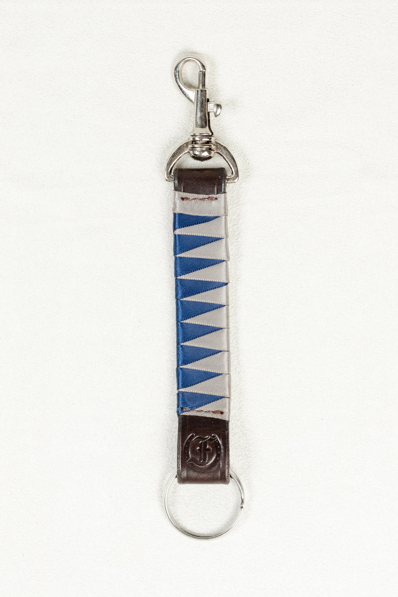 Blue and white satin-finished keychain in dark Havana brown bridle leather with stainless steel clasp and Freedman’s F logo on a white background.