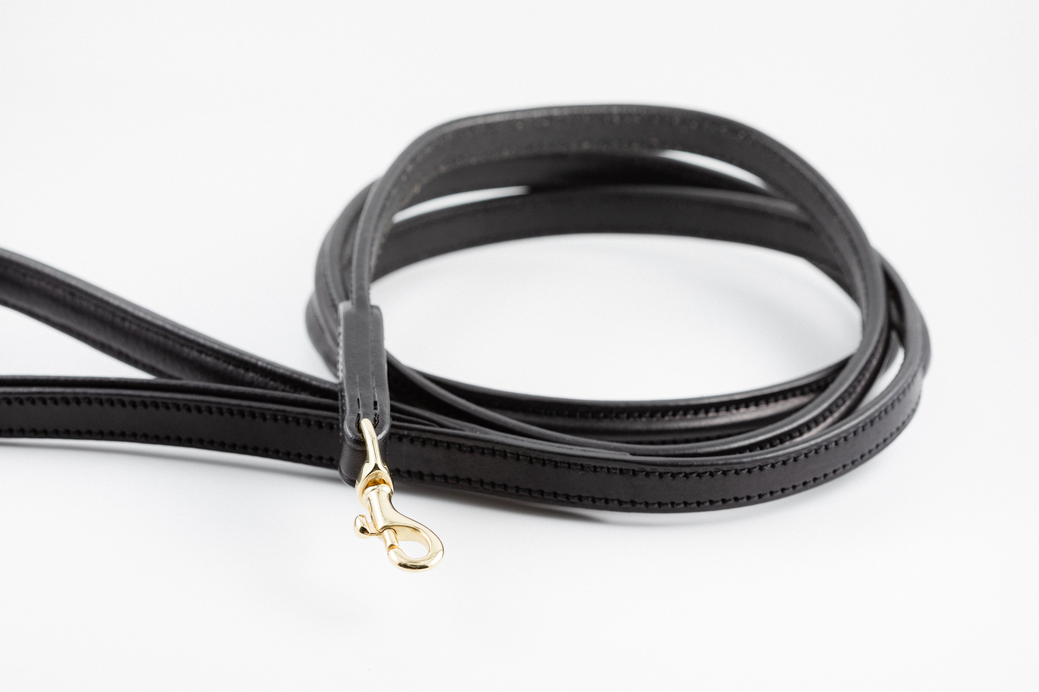 Close-up of black leather Raised Dog Leash showing gold clasp and detailed stitching.
