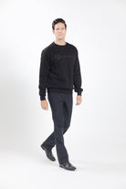 Man wearing Freedman's embroidered crewneck sweatshirts in black. These stylish and cozy sweatshirts feature a tonal Freedman’s logo, perfect for casual wear and layering