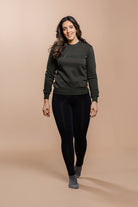 Woman wearing the Olive Green Freedman's embroidered crewneck sweatshirts. These stylish and cozy sweatshirts feature a tonal Freedman’s logo, perfect for casual wear and layering