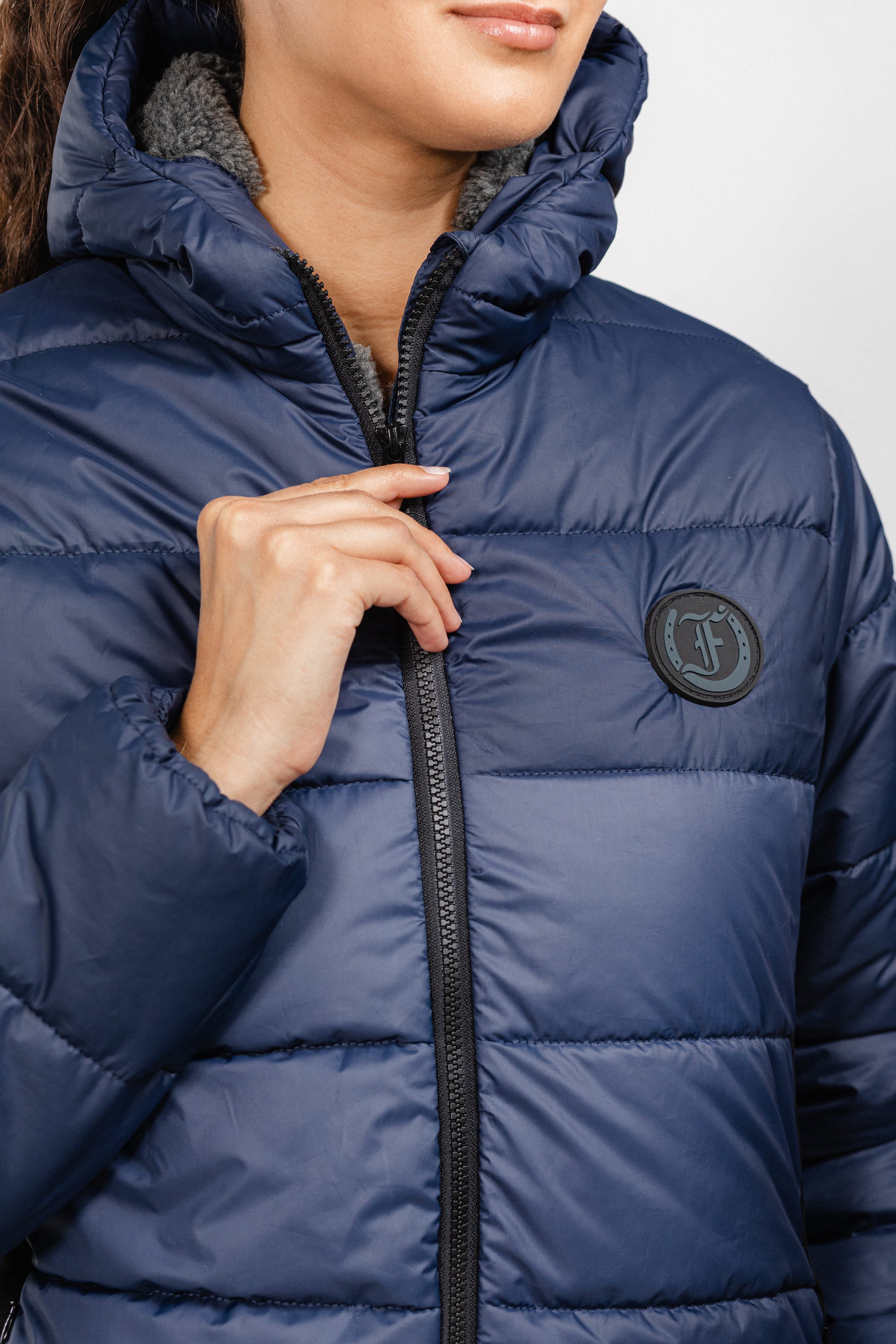 Close-up of navy Ladies Winter Bomber Jacket by Freedman's, showing logo and zipper detail.