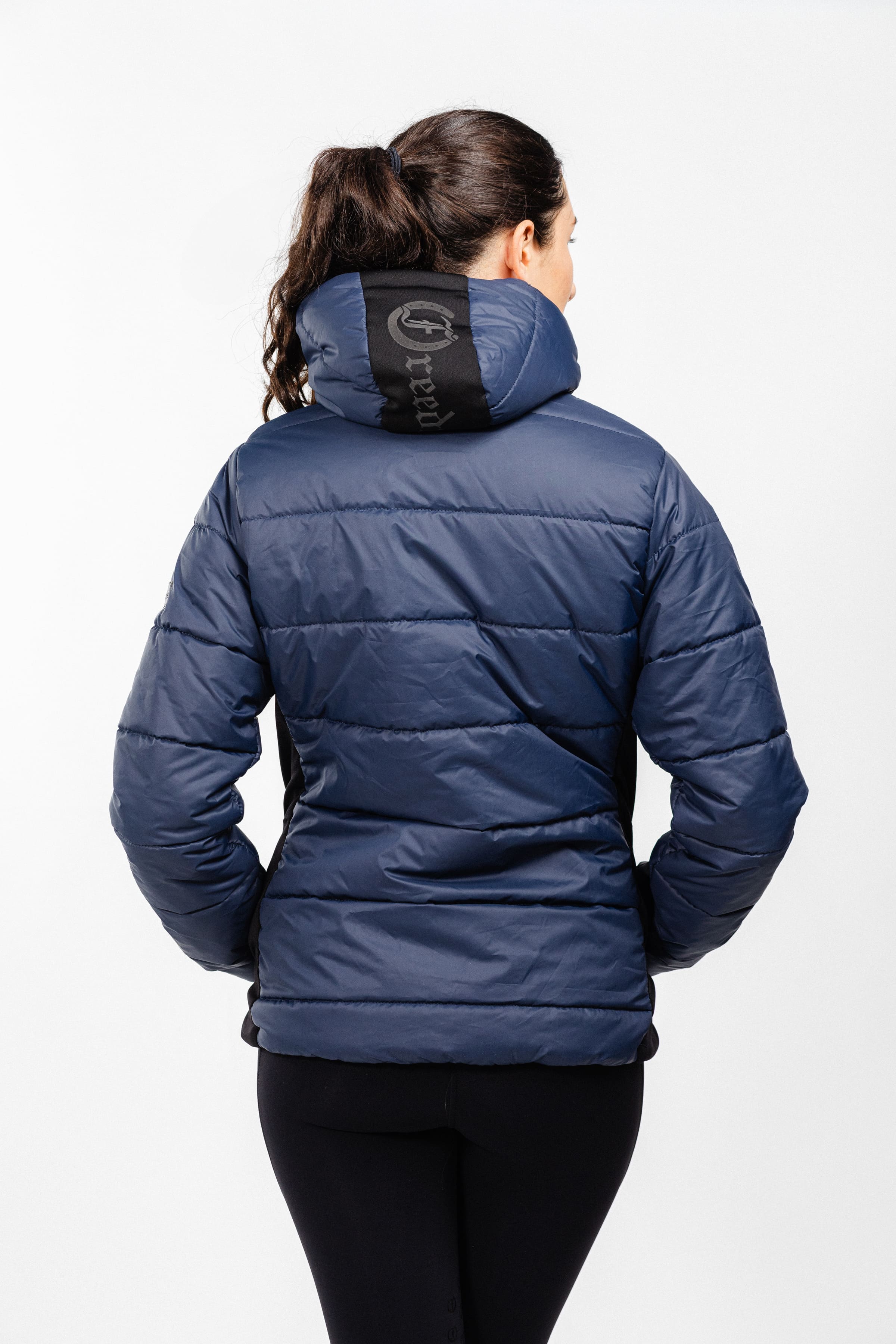 Navy Ladies Winter Bomber Jacket from Freedman's, back view showing quilted design and logo on the hood.