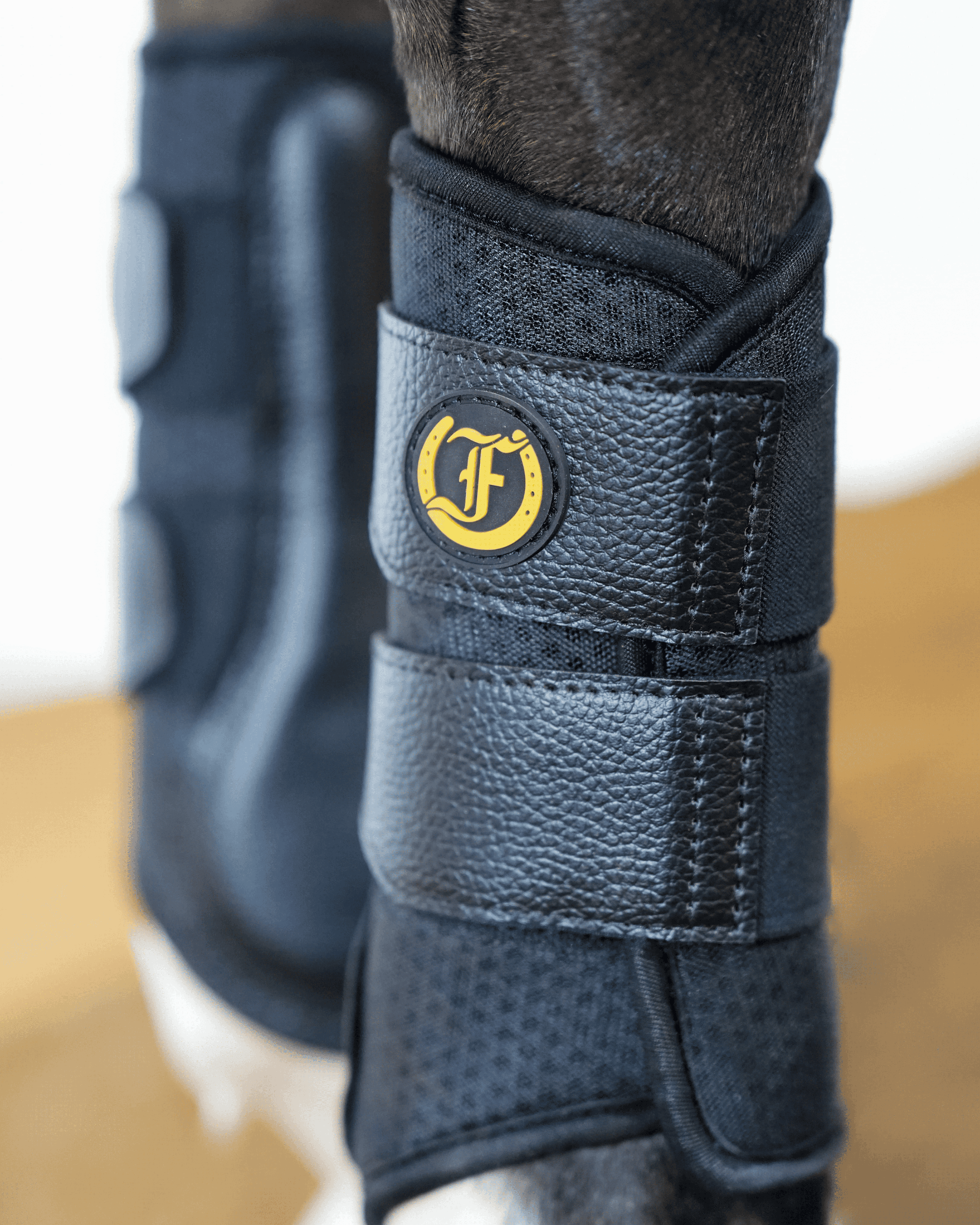 Close-up of Freedman’s black splint boot on horse leg showing protective design and secure strap closure.