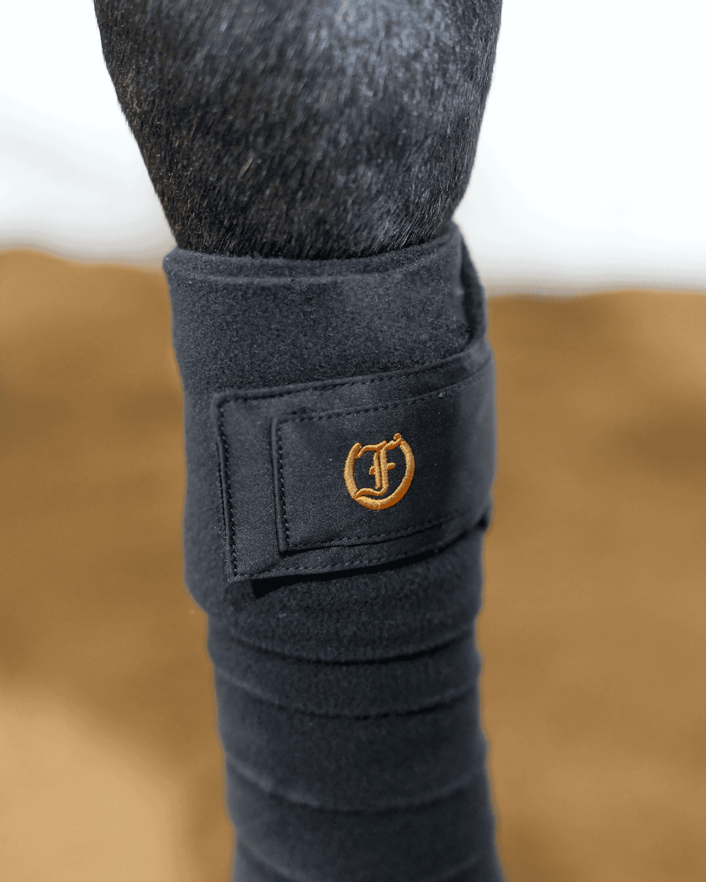Freedman’s black polo wrap on horse leg providing compression support and protection while riding or schooling.
