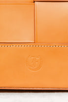 Close-up of Freedman's F logo embossed on cognac leather