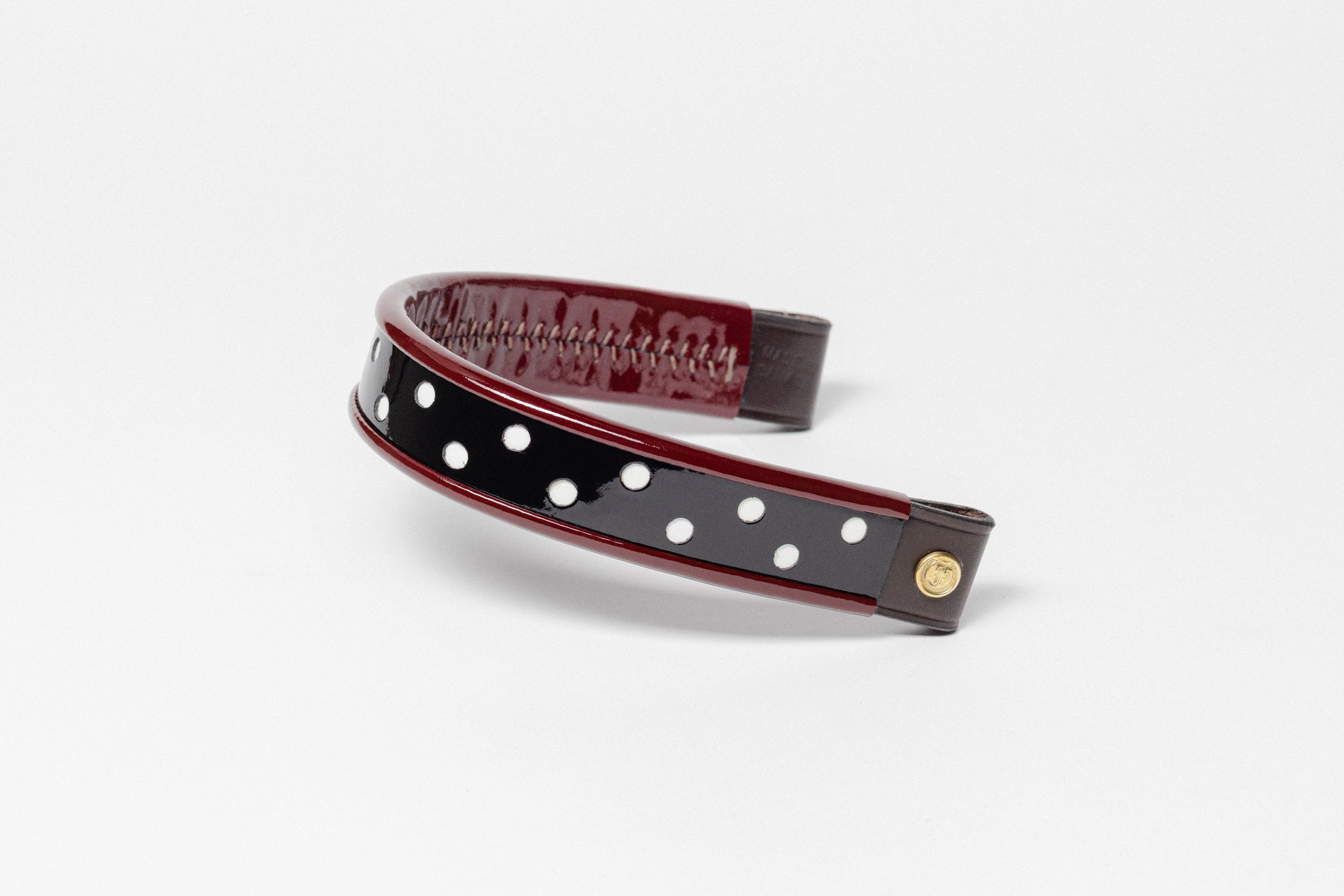 Curved turned edge browband, black patent, red dots, brown leather ends.