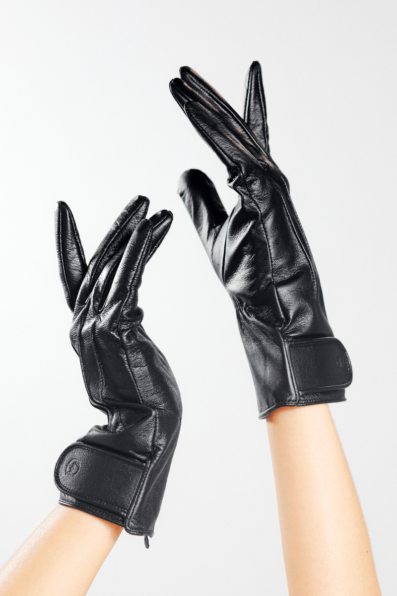 The Yorkville Show Glove, black leather, worn on two hands with palms facing each other, wrist strap and button details visible on each glove, light background