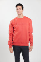Man wearing Freedman's embroidered crewneck sweatshirts in Brick Red. These stylish and cozy sweatshirts feature a tonal Freedman’s logo, perfect for casual wear and layering