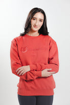 Woman wearing the Brick Red Freedman's embroidered crewneck sweatshirts. These stylish and cozy sweatshirts feature a tonal Freedman’s logo, perfect for casual wear and layering