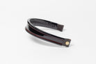 Black and red insert patent leather browband, wide tapered design, turned edge, angled view showing texture and leather ends.