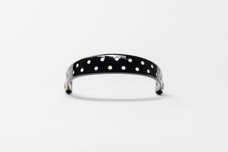 Black browband with white dots, wide tapered design, polished brass Freedman logo buttons, and dark leather ends, frontal view.