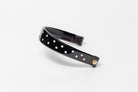 Black Patent Leather Browband with small white dots, wide tapered design, polished brass Freedman logo buttons, and dark leather ends, angled view.