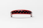 Red and Red dot patent leather browband, wide tapered design, turned edge, dark leather ends with gold button, shown flat.