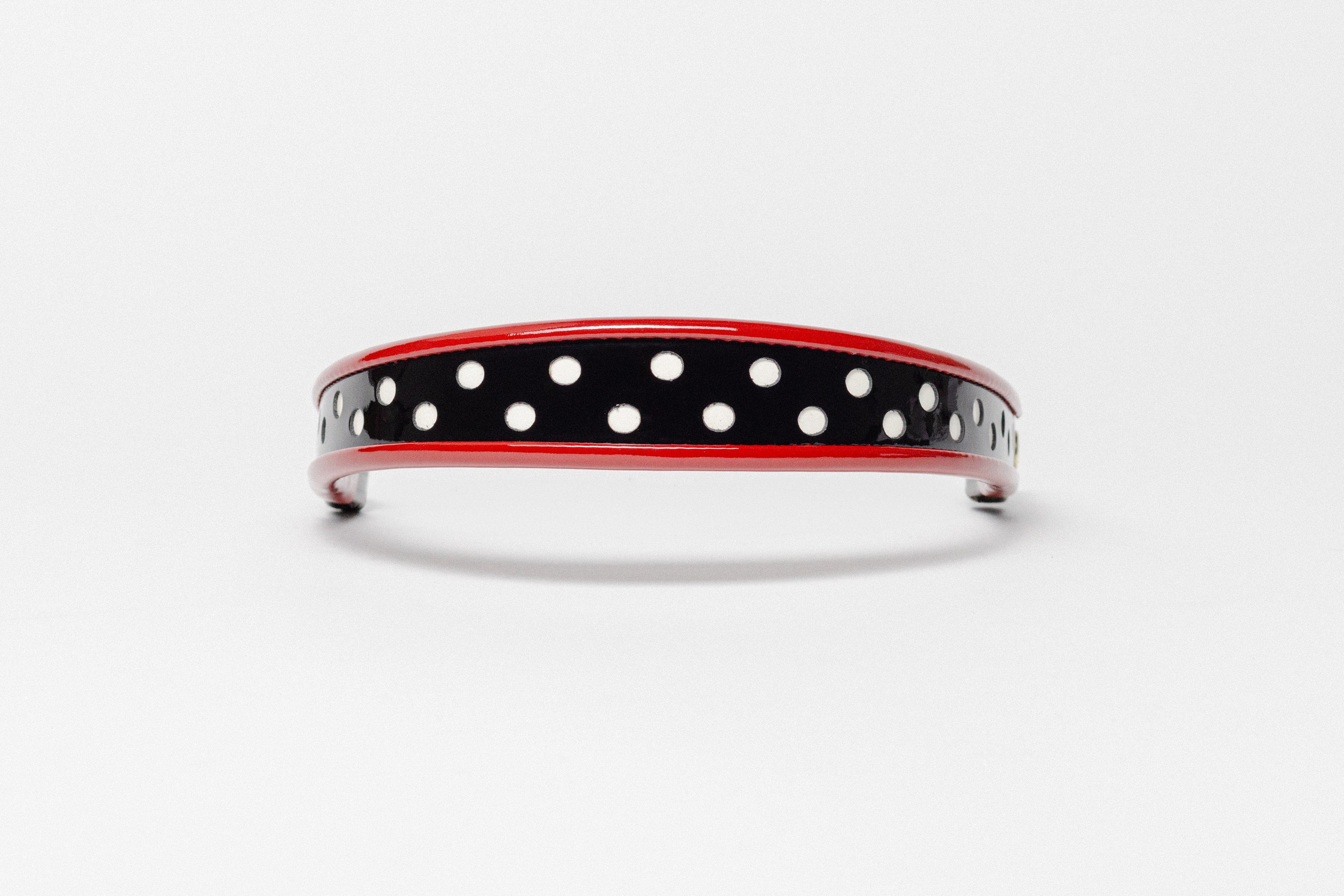 Red and white dot patent leather browband, wide tapered design, turned edge, dark leather ends with gold button, shown Front.