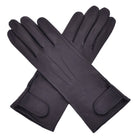  The Yorkville Show Glove, black leather gloves crossed, with wrist strap and button detail, visible seam stitching, light background.