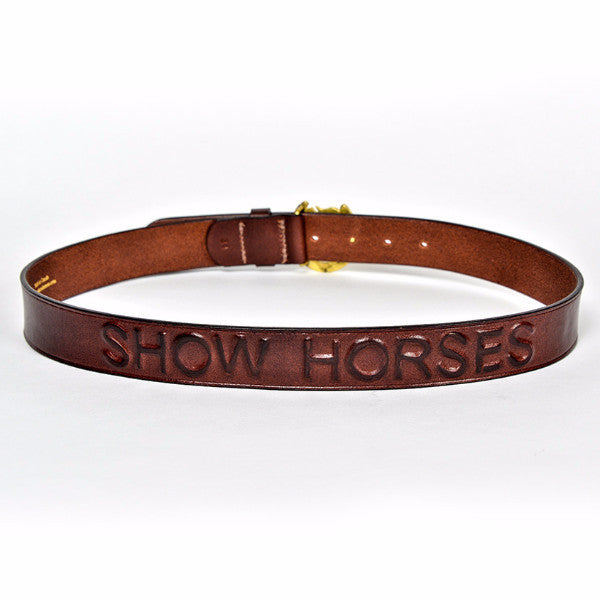 Brown leather belt with "SHOW HORSES" embossed logo and gold buckle.

