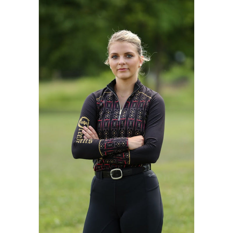 Equestrian athlete wearing the Luna 1/4 Zip Long Sleeve Shirt, a stylish and performance-driven black and red riding top with gold detailing, ideal for horseback riding and outdoor activities.