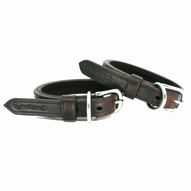 Close-up of ACTraining Ankle Action Straps, highlighting the leather construction, adjustable buckles, detailed stitching, and brand stamping, used for equine training or conditioning.