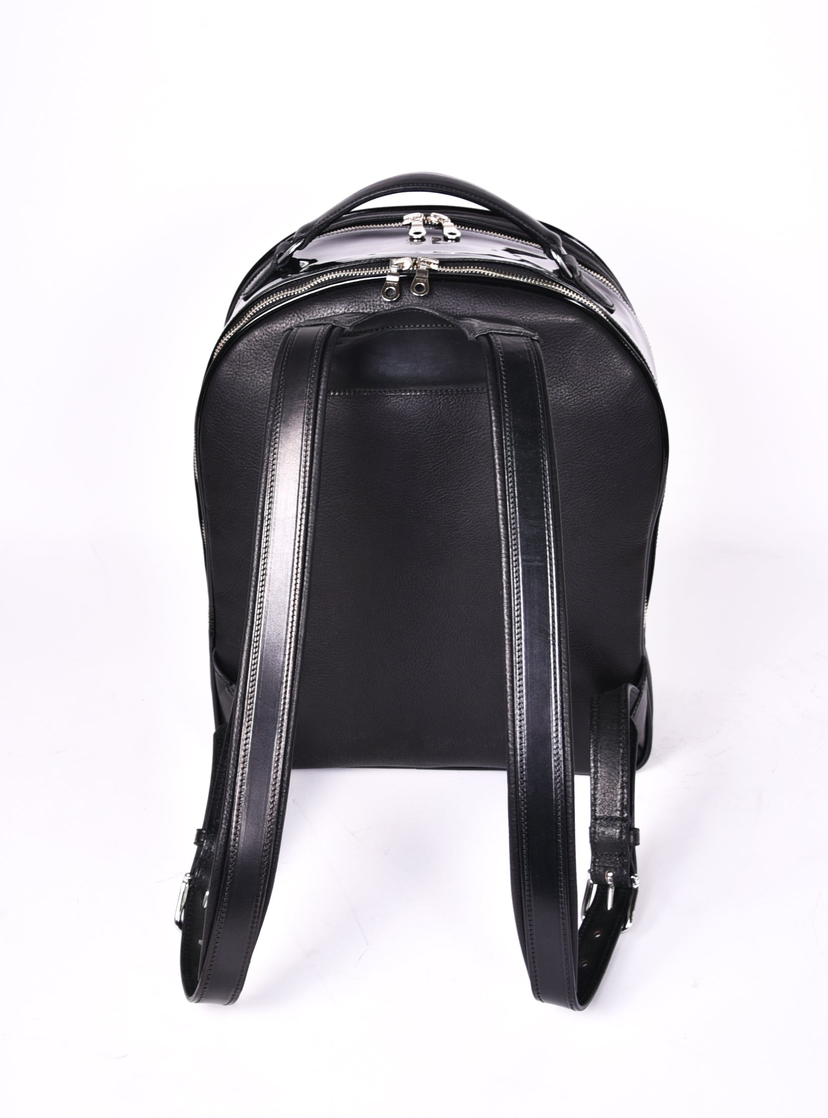 Black leather backpack, The Jaunty by Freedman's, rear view with adjustable shoulder straps and dual zippers.

