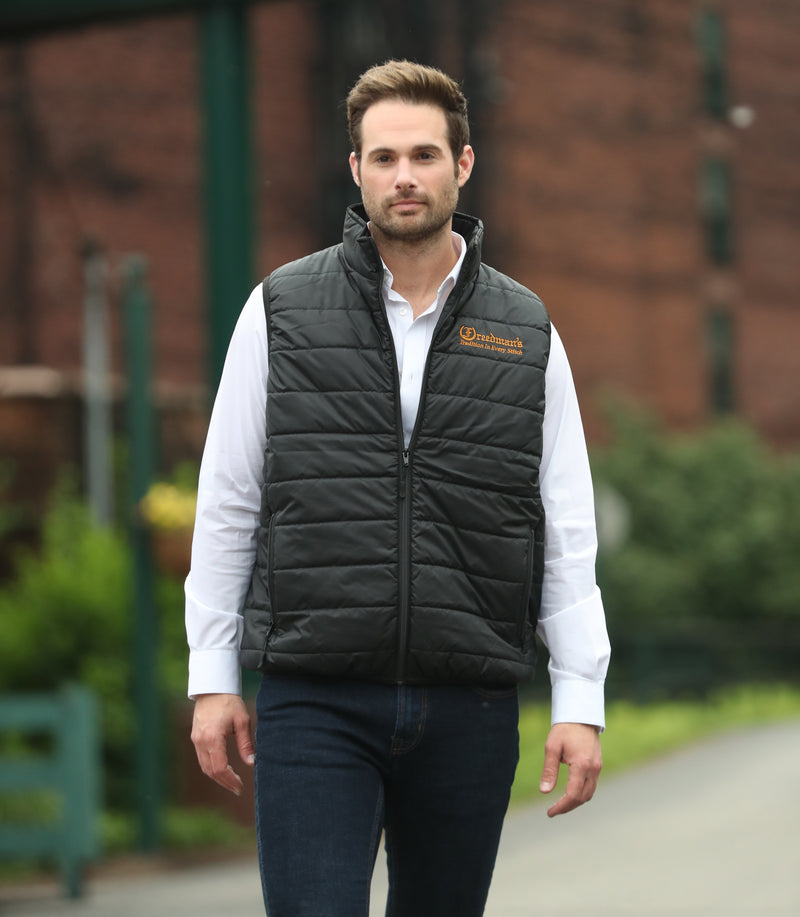 Man wearing Freedman's Men's Insulator Vest in black. This lightweight and stylish vest offers superior warmth and comfort
