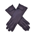 The Yorkville Show Glove, dark navy leather gloves crossed, with wrist strap and button detail, visible seam stitching, light background.