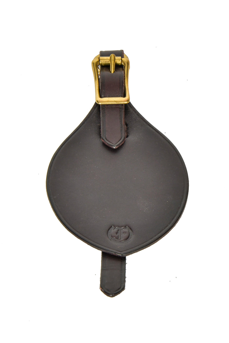 Antique leather horse brass hanger with brass buckle, isolated on a white background.

